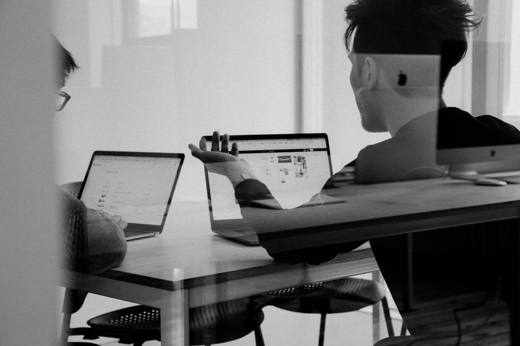 two males in a meeting room discussion